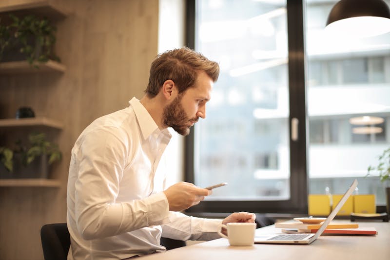 Man in office mobile in hand