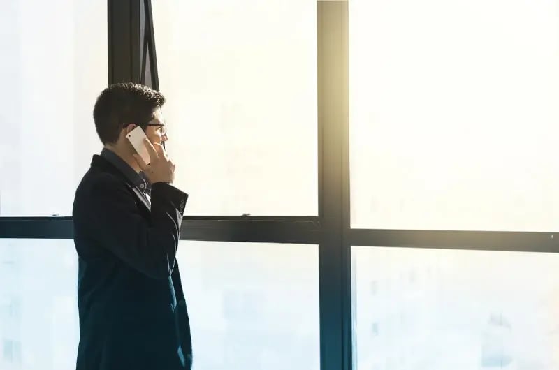 man with phone infront of window