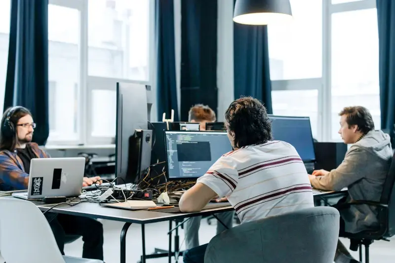 A group of guys working in front of computers A group of guys working in front of computers