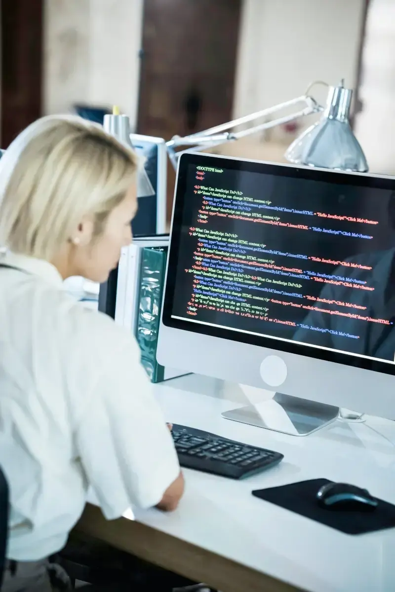 Blonde woman sitting in front of an iMac Blonde woman sitting in front of an iMac