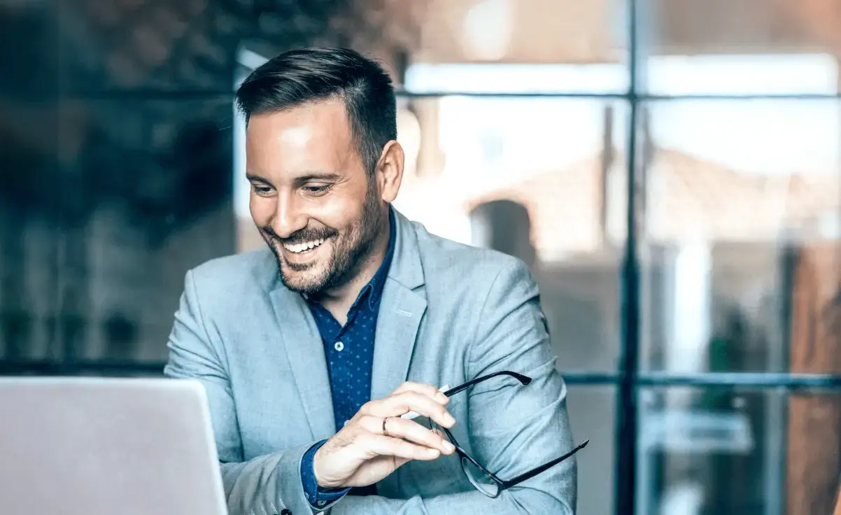Man laughing at a laptop computer