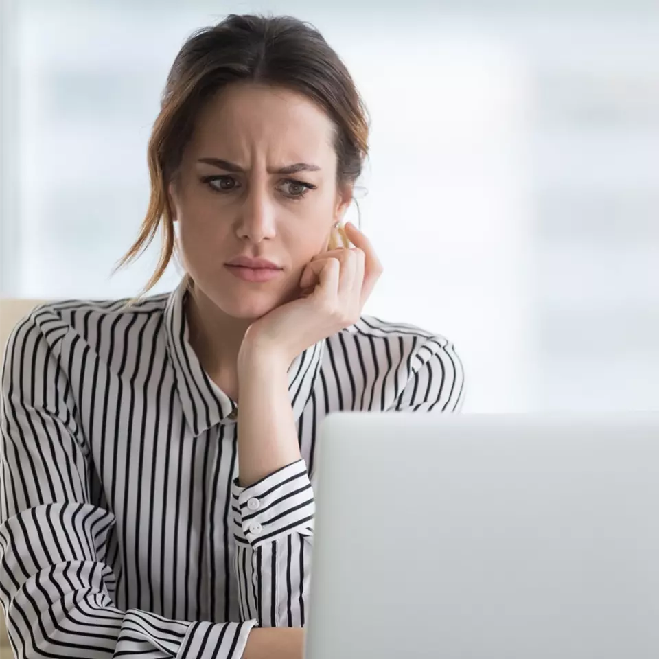 Annoyed woman in front of laptop